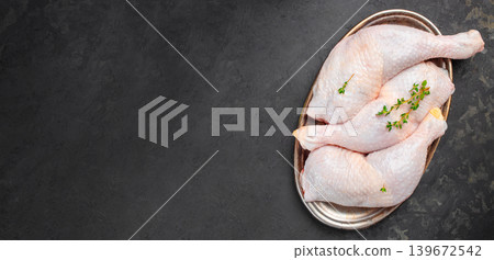 Raw chicken legs on metal tray with herbs on dark background and copy space Raw chicken legs on metal tray with herbs on dark background and copy space 139672542