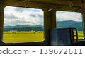 A view from the train window of the Rikuu East Line in Miyagi Prefecture, showing rice fields with drooping ears of grain. 139672611