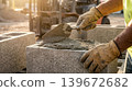 Close Up of Bricklayer Hands Spreading Cement Plaster on Block 139672682