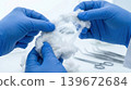 Two hands forcefully pulling raw cotton apart to stretch the internal fibers 139672684