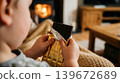 Child Hands Unwrapping Shiny Gold Foil from Large Chocolate Bar 139672689