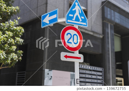 City road signs showing a 20 km/h speed limit and a pedestrian crossing sign side by side. City road signs showing a 20 km/h speed limit and a pedestrian crossing sign side by side. 139672735