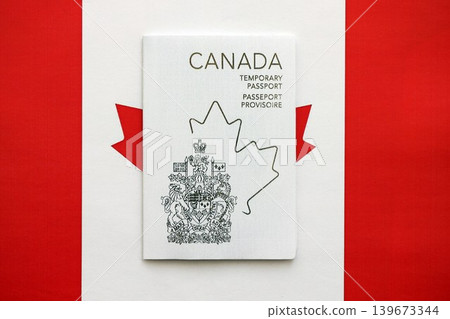 Canadian temporary passport lies on canadian flag Canadian temporary passport lies on canadian flag 139673344