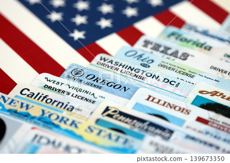 Big amount of driving licenses from different USA states on flag close up Big amount of driving licenses from different USA states on flag close up 139673350