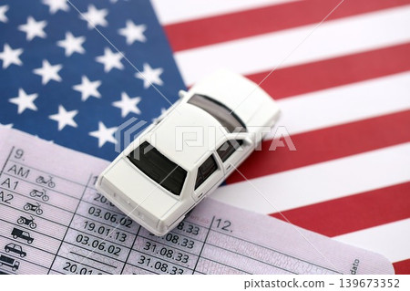 Toy car on driving license close up on United States flag Toy car on driving license close up on United States flag 139673352