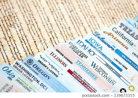 Big amount of driving licenses from different USA states on constitution page Big amount of driving licenses from different USA states on constitution page 139673355