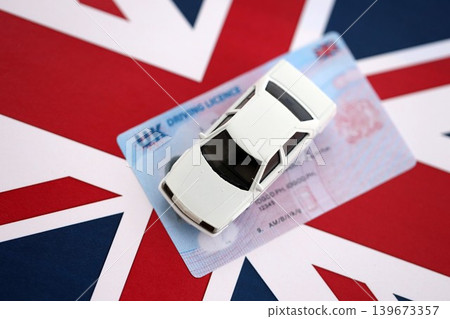 United Kingdom driving license with white toy car on UK flag United Kingdom driving license with white toy car on UK flag 139673357