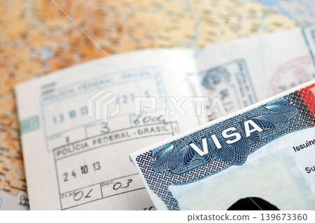 US Embassy visa in passport page with stamps on table US Embassy visa in passport page with stamps on table 139673360
