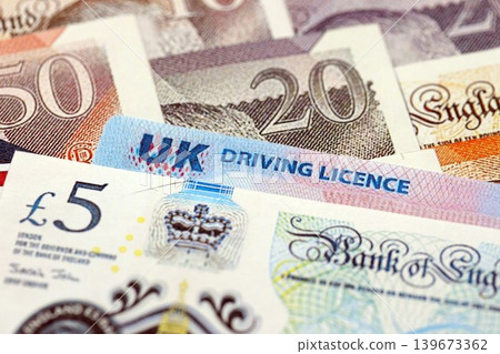 United Kingdom driving license card on UK British pounds money United Kingdom driving license card on UK British pounds money 139673362