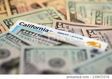 California state driving license among big amount of US dollar bills California state driving license among big amount of US dollar bills 139673370