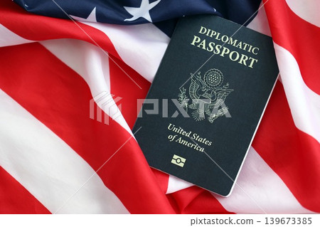 United States diplomatic passport book on US flag close up. Travel document on official banner 139673385