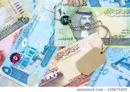 Bahraini dinar currency money bills and military token. The concept of army service Bahraini dinar currency money bills and military token. The concept of army service 139673400