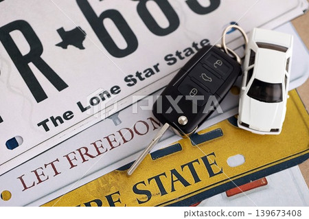 Remote control car keys on US license plates with state names. Driving in United States concept Remote control car keys on US license plates with state names. Driving in United States concept 139673408