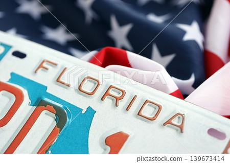 USA state of Florida license plate on US flag. Car driving in Florida USA state of Florida license plate on US flag. Car driving in Florida 139673414
