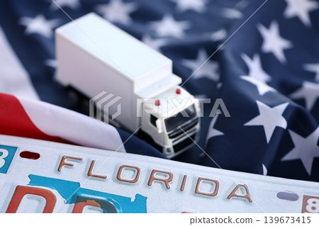 Toy truck and USA state of Florida license plate on US flag. Car driving in Florida 139673415