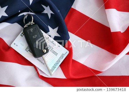 Ignition keys with remote control buttons and driver license card on United States flag Ignition keys with remote control buttons and driver license card on United States flag 139673418