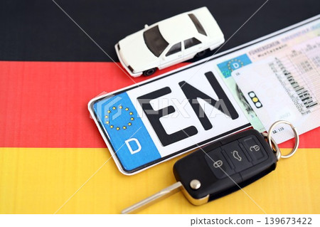Germany Deutschland car license plate and ignition key on german flag close up. Driving permit Germany Deutschland car license plate and ignition key on german flag close up. Driving permit 139673422