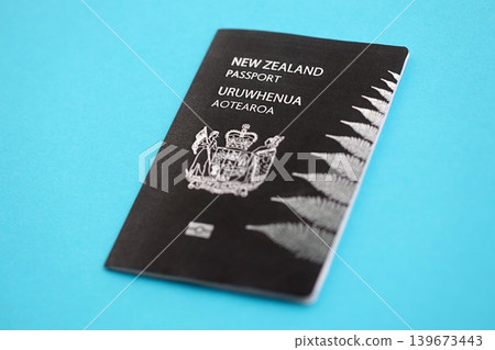 New Zealand black passport on light blue table background. Concept of travel and tourism New Zealand black passport on light blue table background. Concept of travel and tourism 139673443
