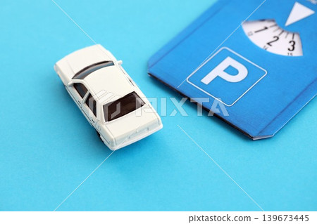 Parking disc for windshield and white toy car. Limited time parking system in european countries Parking disc for windshield and white toy car. Limited time parking system in european countries 139673445