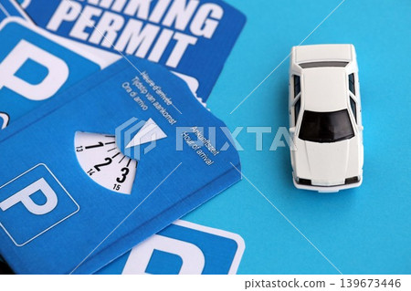 Parking permit paper tag and parking disc with toy car. Parking permit for people with disabilities Parking permit paper tag and parking disc with toy car. Parking permit for people with disabilities 139673446