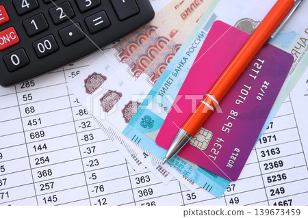 Credit card and pen with russian ruble currency money bills banknotes on calculations document Credit card and pen with russian ruble currency money bills banknotes on calculations document 139673459