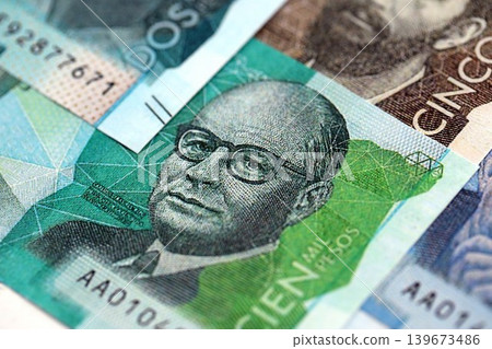 Colombian pesos money bills banknotes lies in big pile on table close up. Finances and business 139673486