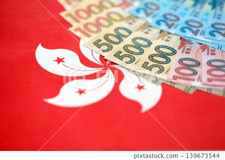 Big pile of Hong Kong dollars money bills banknotes on red flag. Money of Chinese HKD currency Big pile of Hong Kong dollars money bills banknotes on red flag. Money of Chinese HKD currency 139673544