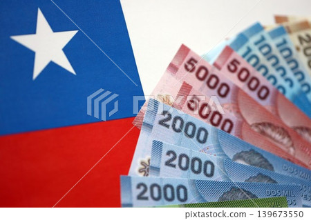 Chile Republic pesos money bills banknotes on flag close up. Chilean money 139673550