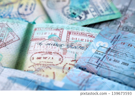 Big amount of passport pages full of colorful stamps after travel and border crossing Big amount of passport pages full of colorful stamps after travel and border crossing 139673593