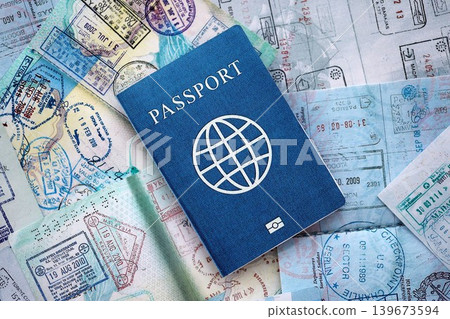 One fictional passport on big amount of passport pages full of colorful stamps after travel One fictional passport on big amount of passport pages full of colorful stamps after travel 139673594