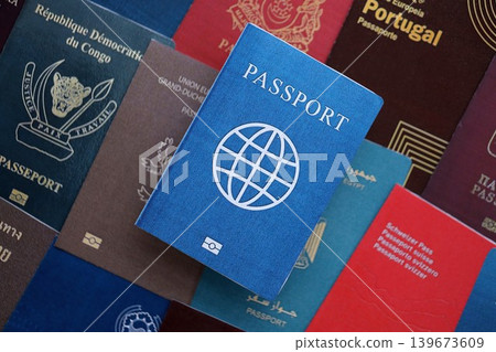 Fictional passport book travel document on big amount of real passport covers Fictional passport book travel document on big amount of real passport covers 139673609