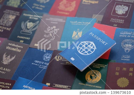 Fictional passport book travel document on big amount of real passport covers Fictional passport book travel document on big amount of real passport covers 139673610