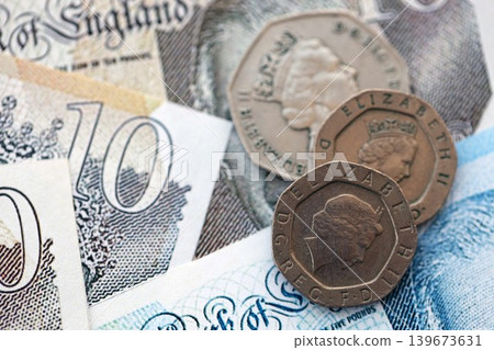 Coins and banknotes of United Kingdom and Great Britain pound currency. UK money close up Coins and banknotes of United Kingdom and Great Britain pound currency. UK money close up 139673631