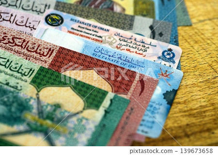 Oman resident card and driving license among Oman rial money bills on table close up 139673658