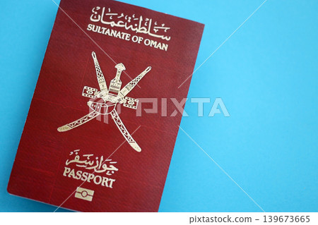 Omani passport on table close up. Official identification document book for citizens of Oman Omani passport on table close up. Official identification document book for citizens of Oman 139673665