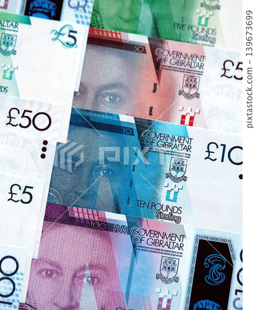 Gibraltar pound paper banknotes pile on table. Gibraltar GIP currency money bills in big amount Gibraltar pound paper banknotes pile on table. Gibraltar GIP currency money bills in big amount 139673699