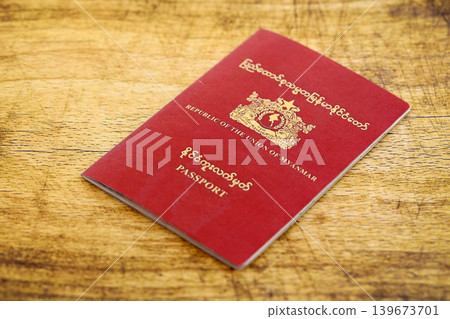 Myanmar passport on table close up. Official identification document book for citizens of Myanmar Myanmar passport on table close up. Official identification document book for citizens of Myanmar 139673701