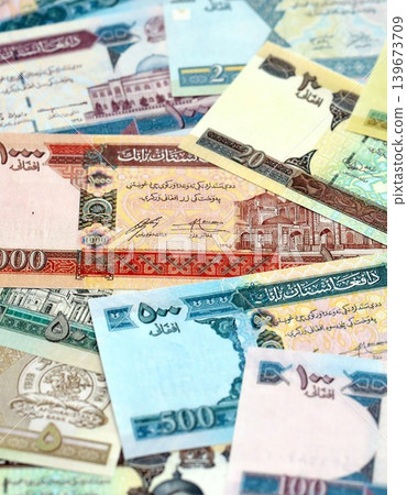 Afghan afghani paper banknotes pile on table. Afghanistan AFN currency money bills in big amount Afghan afghani paper banknotes pile on table. Afghanistan AFN currency money bills in big amount 139673709