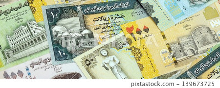Yemeni rial paper banknotes pile on table. Yemen YER currency money bills in big amount Yemeni rial paper banknotes pile on table. Yemen YER currency money bills in big amount 139673725