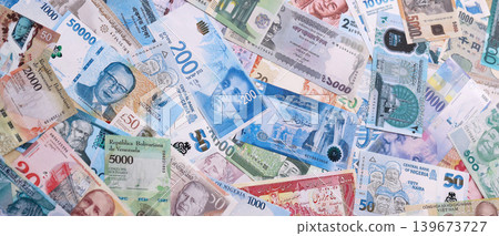 Different colorful banknotes from many various currencies of the world. Big stack of money bills Different colorful banknotes from many various currencies of the world. Big stack of money bills 139673727