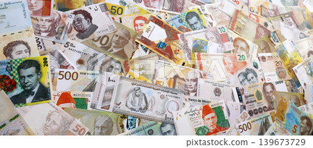 Various currencies money bills banknotes in yellow and orange color. Many cash bills Various currencies money bills banknotes in yellow and orange color. Many cash bills 139673729