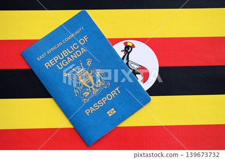 Ugandan passport on flag close up. Official identification document book for citizens of Uganda Ugandan passport on flag close up. Official identification document book for citizens of Uganda 139673732