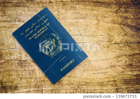 Afghan passport on table. Official identification document book for citizens of Afghanistan Afghan passport on table. Official identification document book for citizens of Afghanistan 139673733