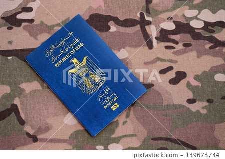 Iraqi passport on table close up. Official identification document book for citizens of Iraq Iraqi passport on table close up. Official identification document book for citizens of Iraq 139673734