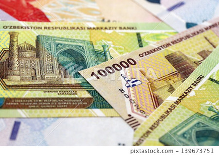 Uzbek som money bills pile on table. Uzbekistan banknotes of UZN currency close up Uzbek som money bills pile on table. Uzbekistan banknotes of UZN currency close up 139673751