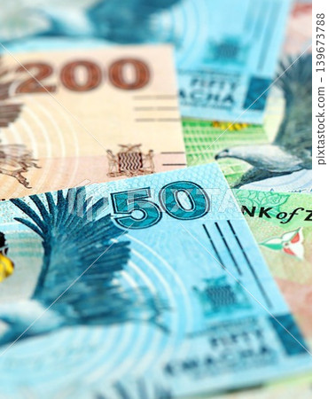 Zambian kwacha money bills pile on table. Zambia banknotes of ZMW currency close up Zambian kwacha money bills pile on table. Zambia banknotes of ZMW currency close up 139673788