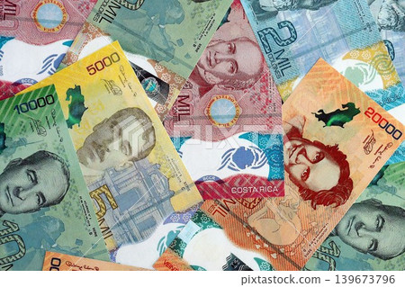 Costa Rican new colon money bills pile on table. Costa Rica banknotes of CRC currency close up Costa Rican new colon money bills pile on table. Costa Rica banknotes of CRC currency close up 139673796