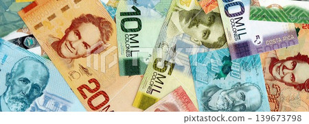 Costa Rican colon money bills pile on table. Costa Rica banknotes of CRC currency close up Costa Rican colon money bills pile on table. Costa Rica banknotes of CRC currency close up 139673798