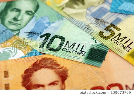 Costa Rican colon money bills pile on table. Costa Rica banknotes of CRC currency close up Costa Rican colon money bills pile on table. Costa Rica banknotes of CRC currency close up 139673799