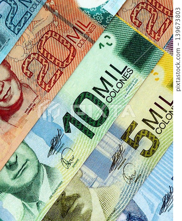 Costa Rican colon money bills pile on table. Costa Rica banknotes of CRC currency close up Costa Rican colon money bills pile on table. Costa Rica banknotes of CRC currency close up 139673803